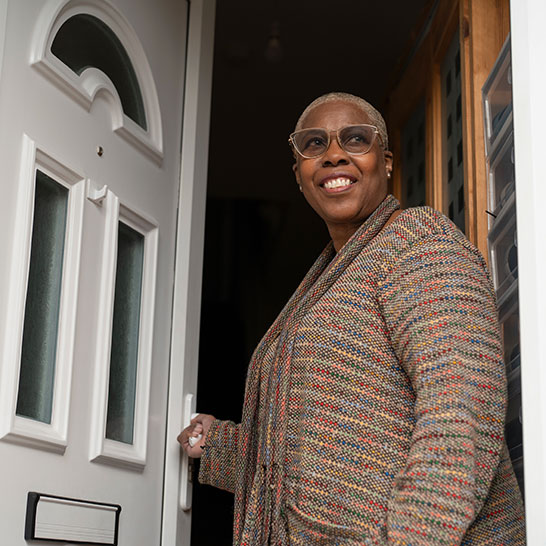 Image showing a lady at at an open door smiling